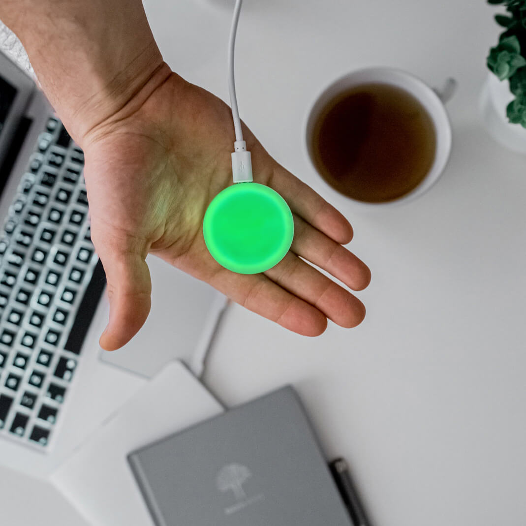 Luxafor Mute Button Busylight hvid lyser grønt på hånd